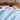 Man sleeping under a light blue cooling comforter in a cozy bedroom