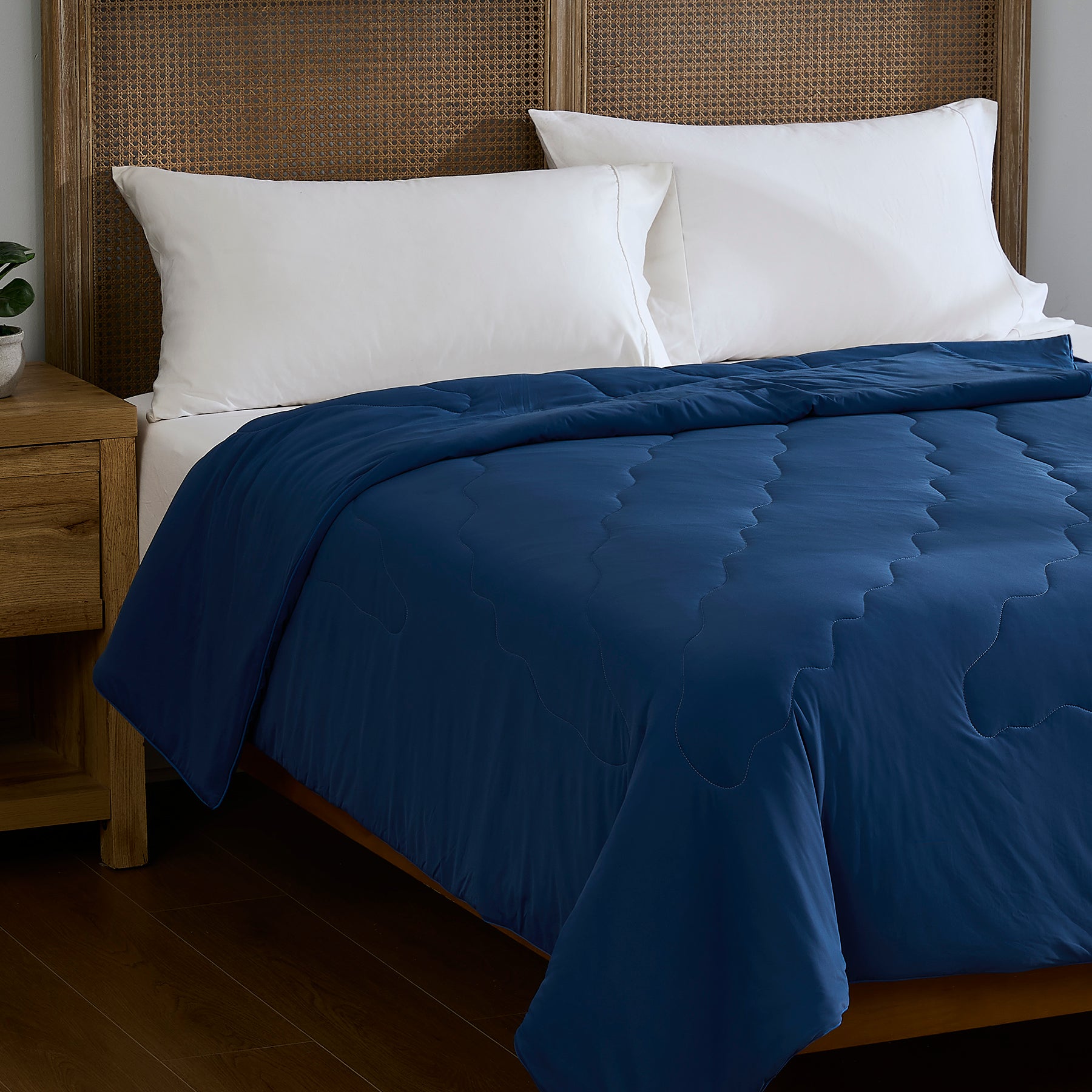 Blue breathable cooling comforter styled on a bedroom bed