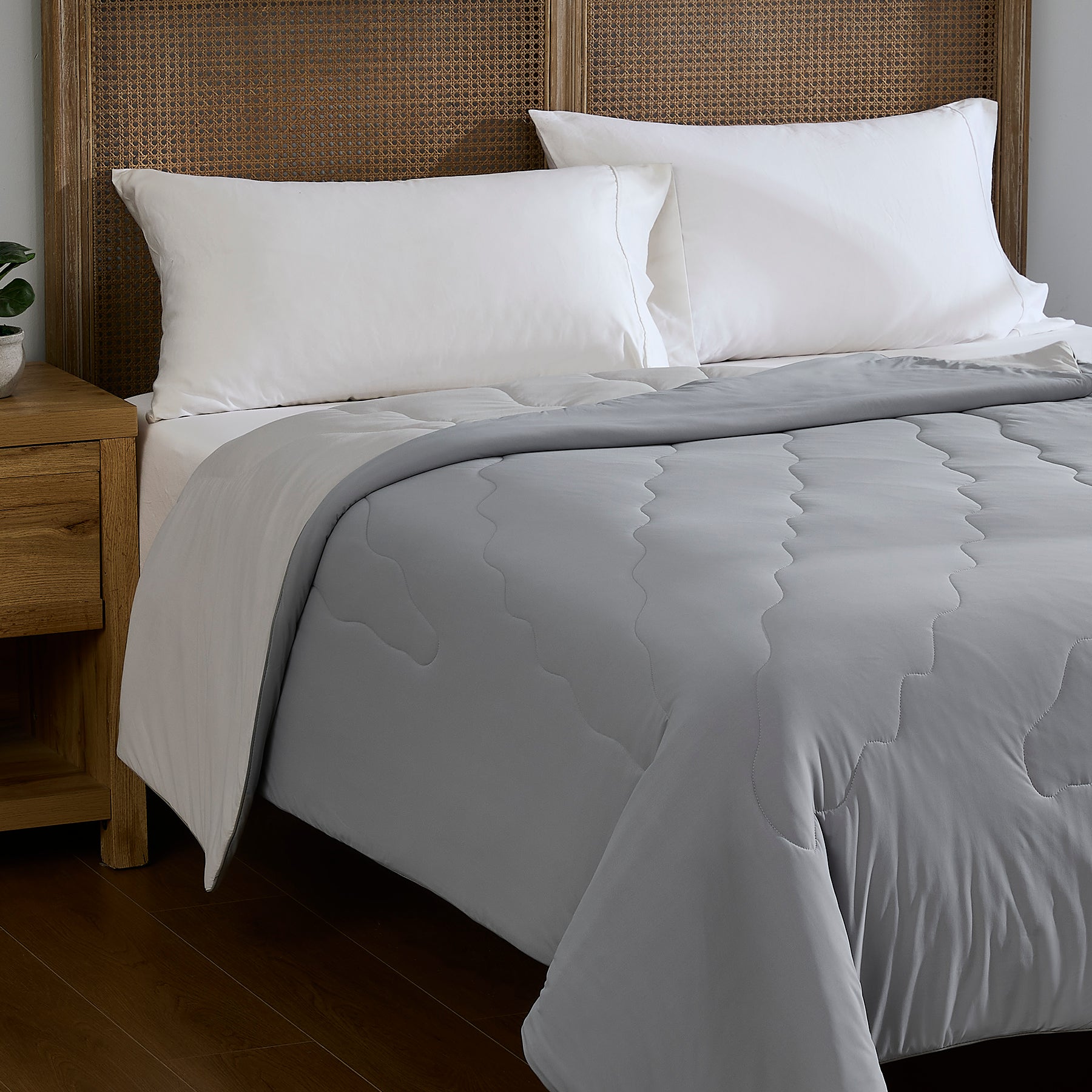 Gray lightweight cooling comforter styled on a bedroom bed