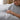 Woman touching a gray cooling comforter with a soft smooth surface