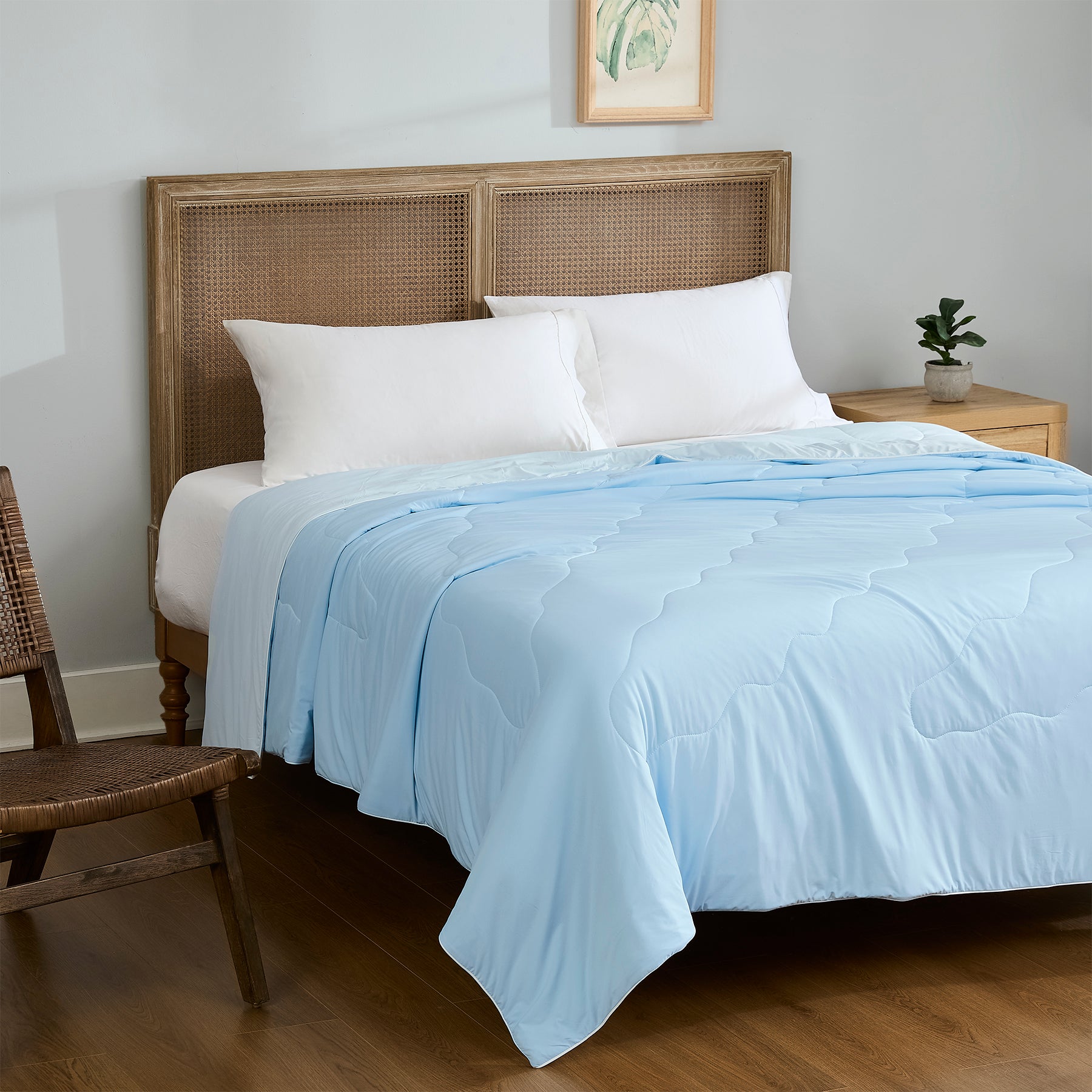 Light blue lightweight cooling comforter styled on a bedroom bed