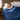 Woman sleeping under a navy cooling comforter in a cozy bedroom
