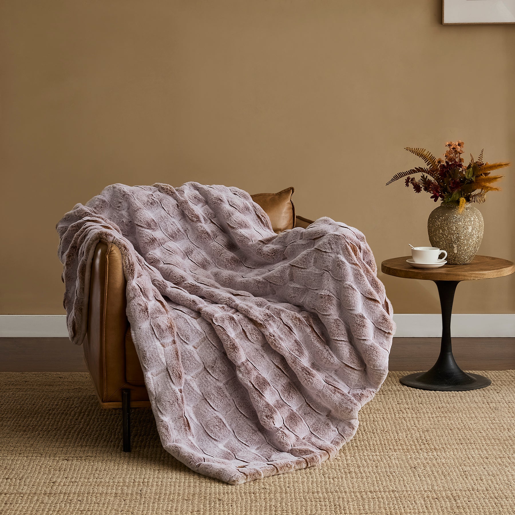 Pink ripple plush blanket draped over an armchair in a cozy living room
