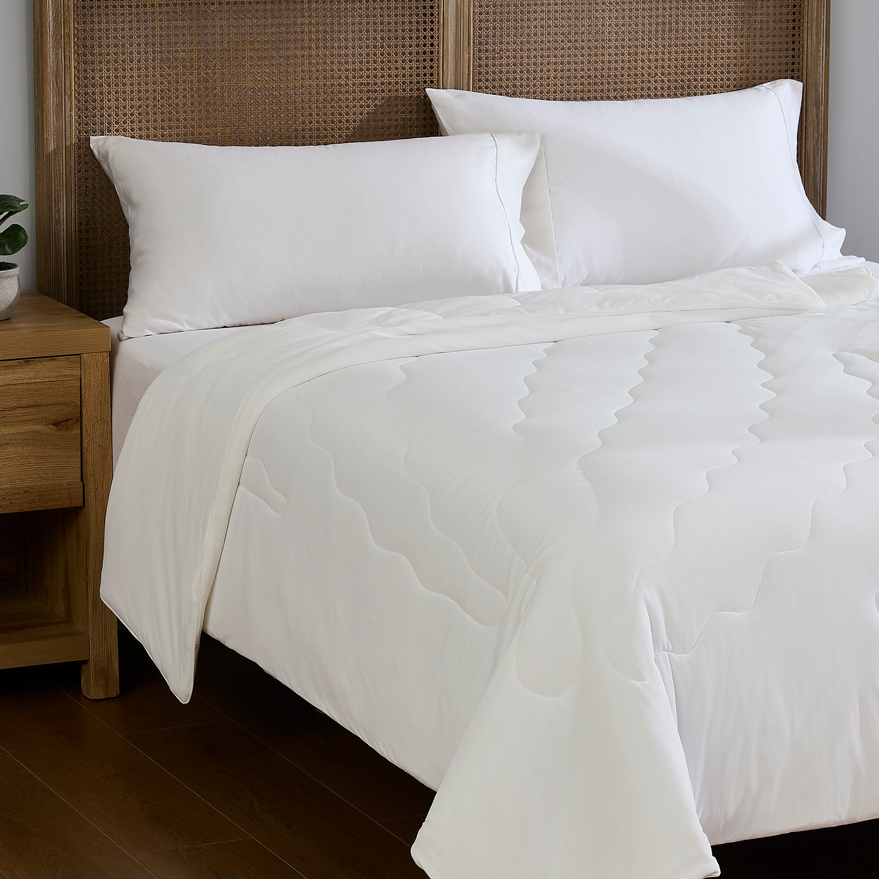 White breathable cooling comforter styled on a bedroom bed