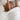 Woman waking up under a white cooling comforter in a bright bedroom